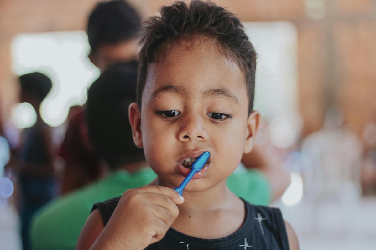 Child brushing teeth as part of healthy family dental care in Avon, Indiana